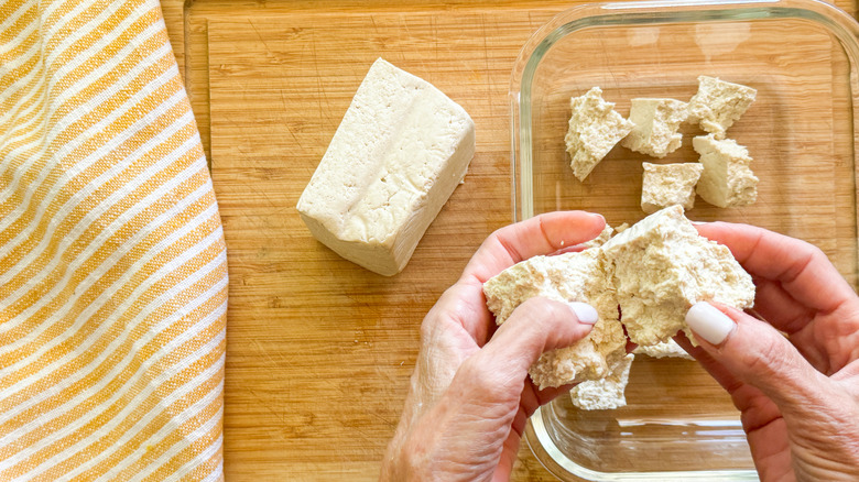 hands tearing tofu