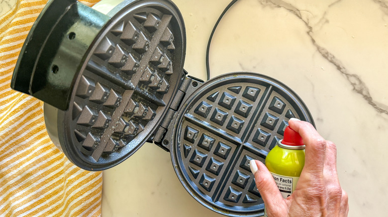 hand spraying waffle iron