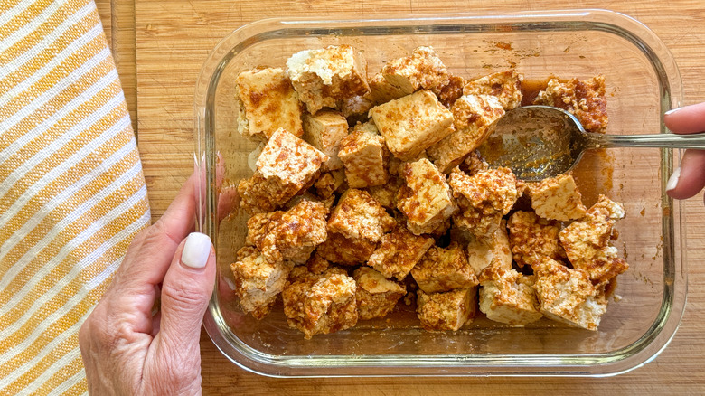 hand mixing tofu and marinade