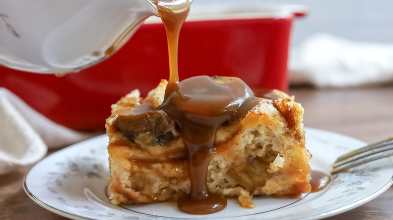 a slice of bread pudding with caramel being poured over it