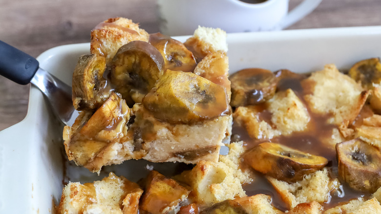 sweet plantain bread pudding being cut and served