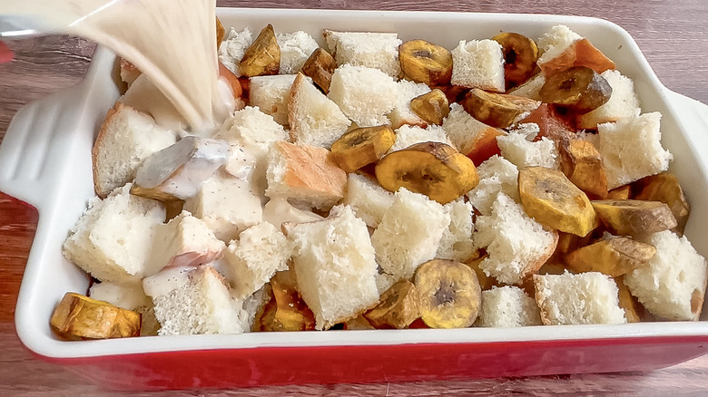 custard being poured over bread and plantains