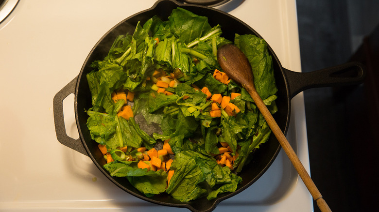 greens sauteeing in iron skillet 