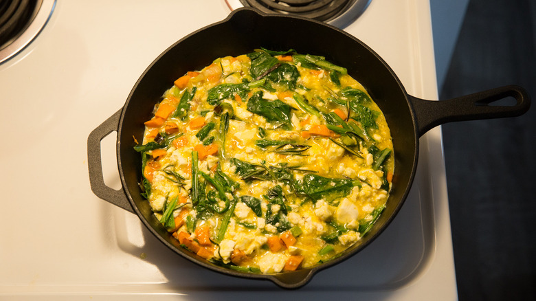 frittata cooking in stovetop skillet 