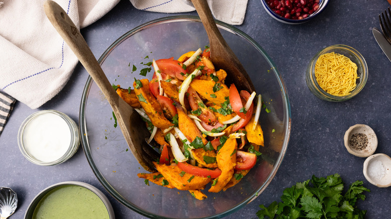 Chaat ingredients in glass bowl with spoons