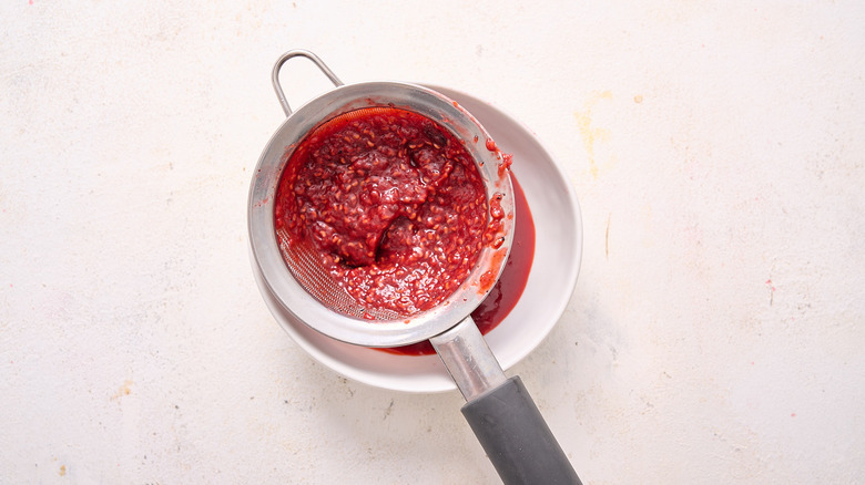 straining barbecue sauce into bowl