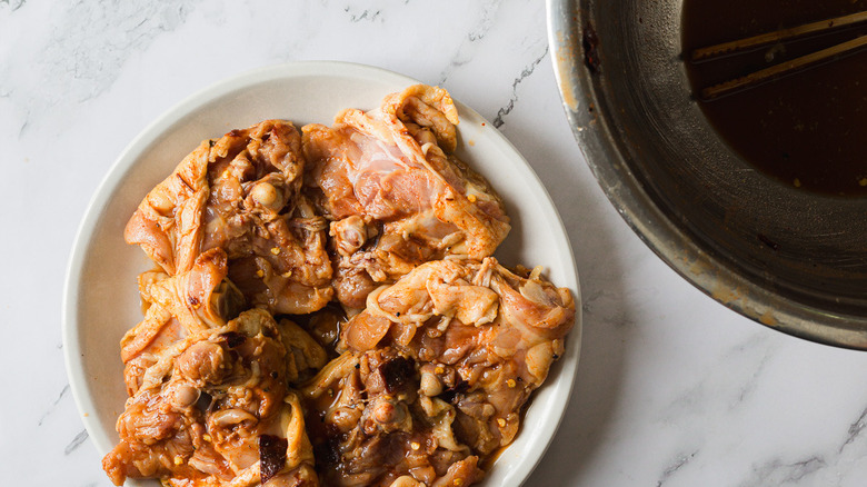 Marinated chicken beside bowl