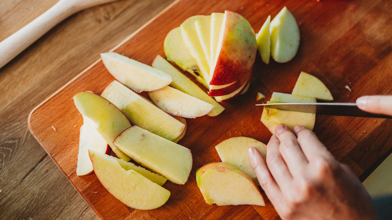 Close up of hand slicing apples 