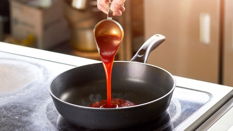 Close up of ketchup being poured into pot 