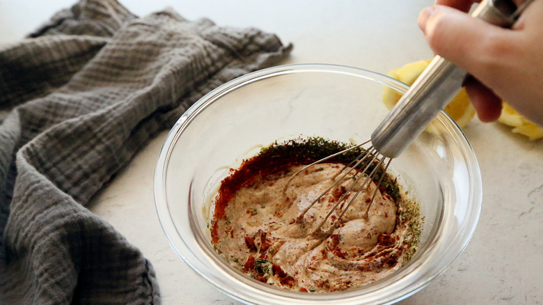 whisking tahini marinade in bowl