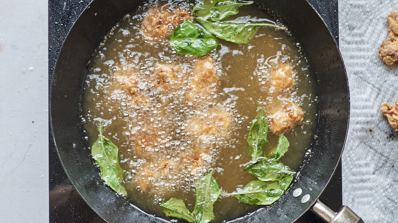 basil and chicken frying in wok