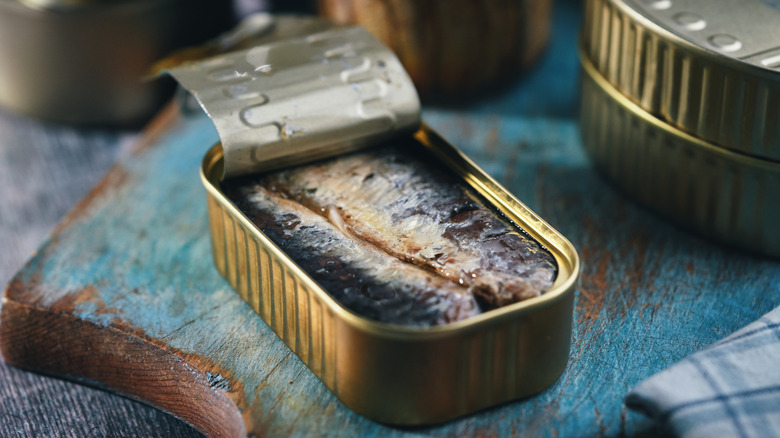 canned sardines on cutting board 