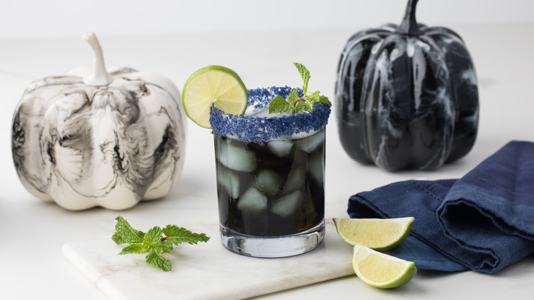 black vodka cocktail with halloween pumpkin