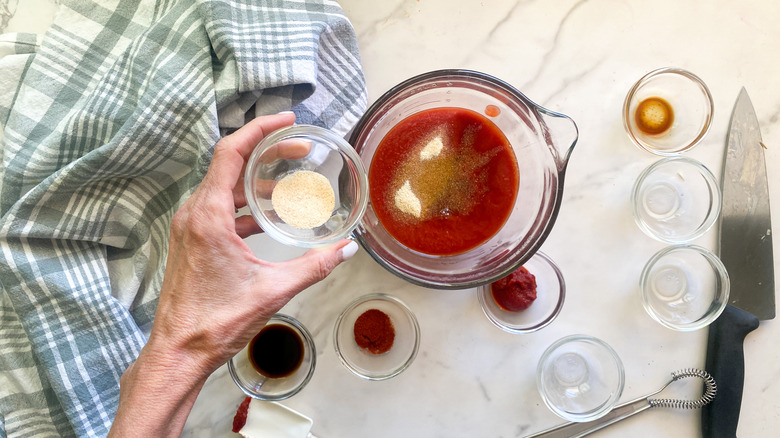 adding ingredients to glass bowl with sauce