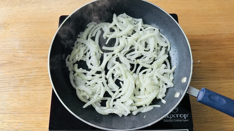 onion pieces cooking in skillet