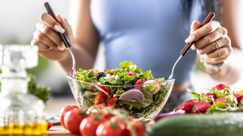 Tossing salad in bowl