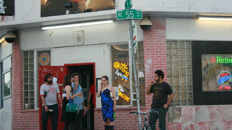 Folks standing outside of a bar