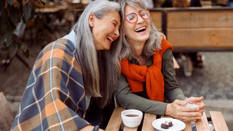 Two women with coffee laughing