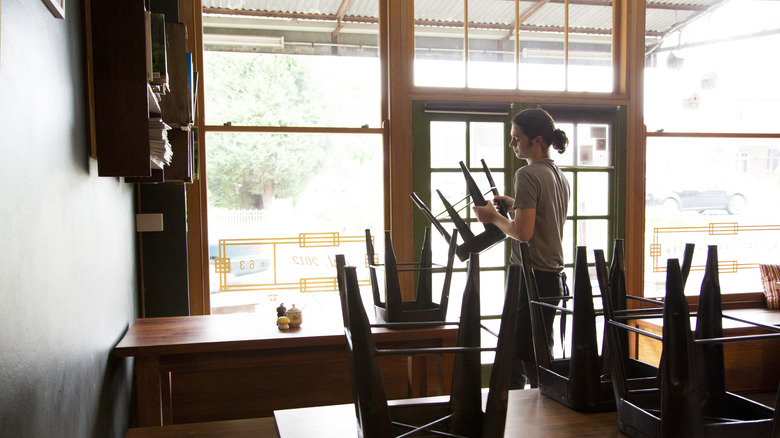 restaurant server putting up chairs