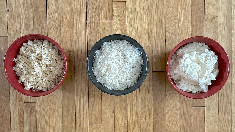 Three bowls with cooked brown rice, basmati rice, and arborio rice