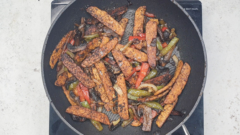 Tempeh and veggies cooking in pan 