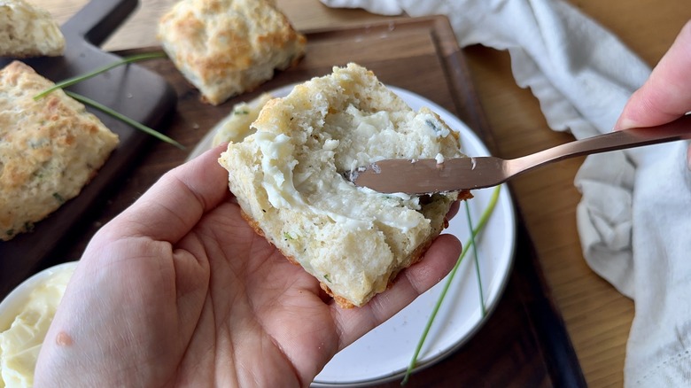 spreading butter onto biscuit