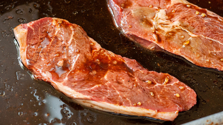 uncooked marinated steak in plate