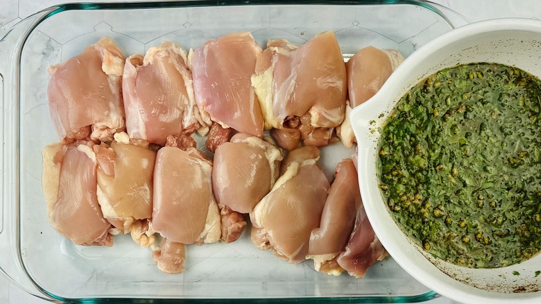 pouring marinade over raw chicken 