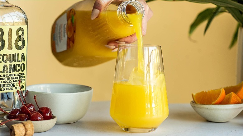 pouring orange juice into glass