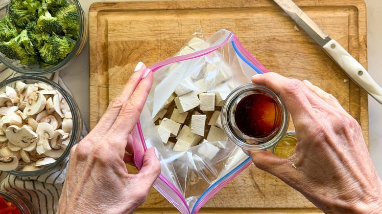 adding soy sauce to tofu