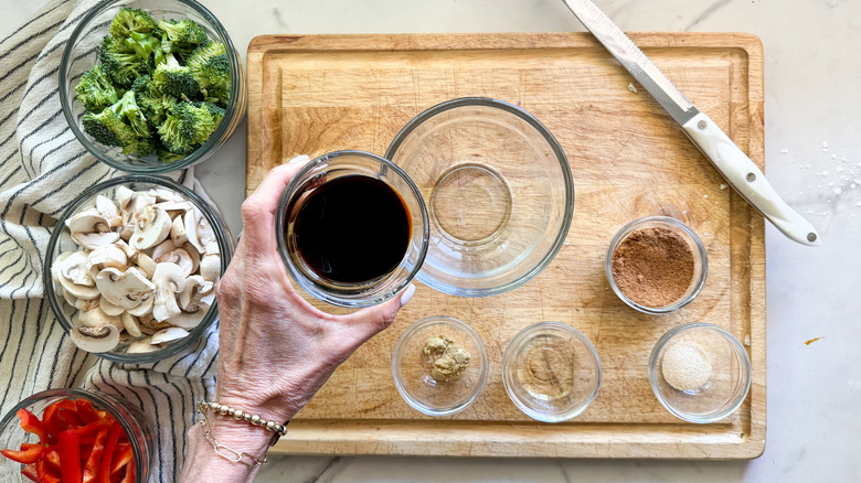 adding soy sauce to bowl