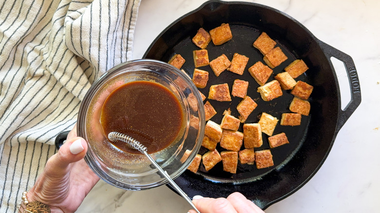 adding sauce to tofu