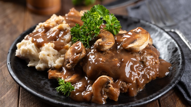 Smothered steak with mushrooms and mashed potatoes