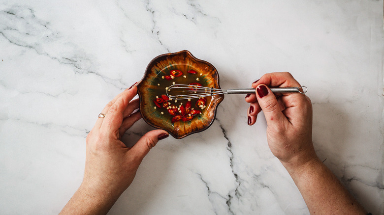 Hands whisking dipping sauce