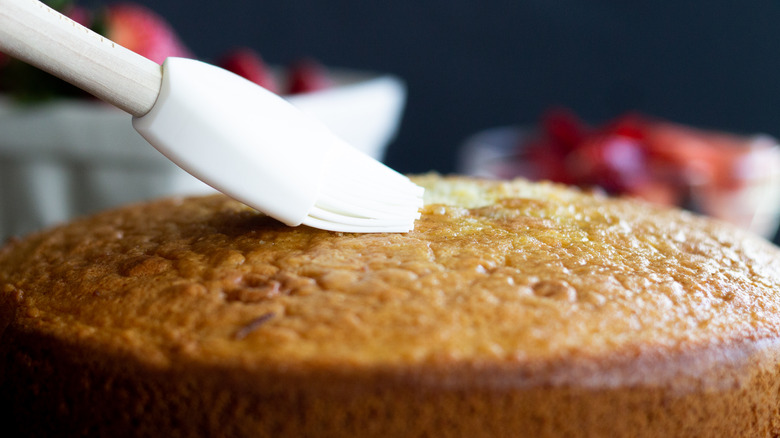 brushing cake with simple syrup