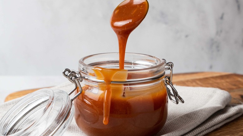 spoon dripping with caramel sauce