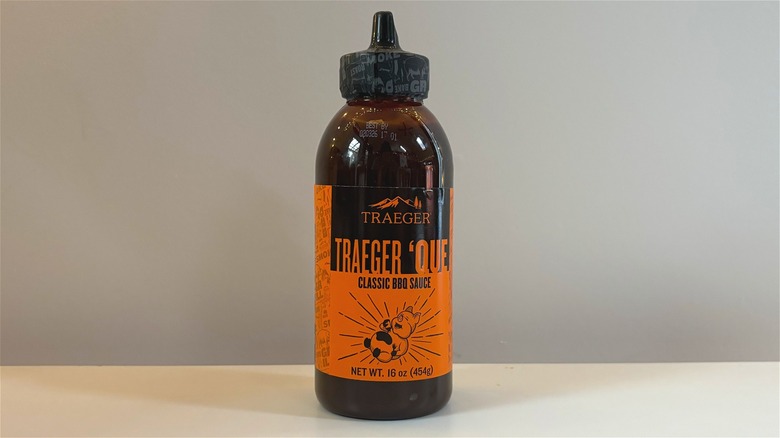 Bottle of Traeger 'Que Classic BBQ Sauce on white table