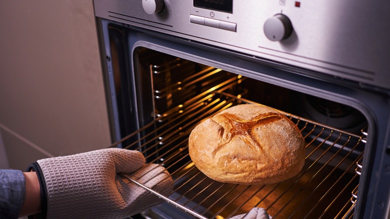 Taking bread loaf out of oven