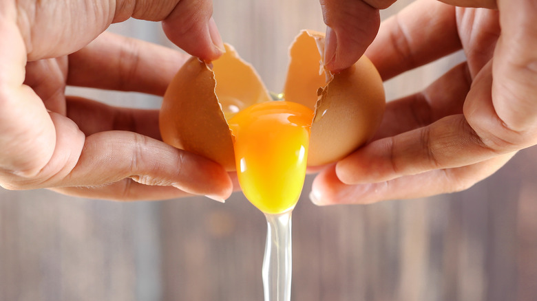 Two hands cracking an egg