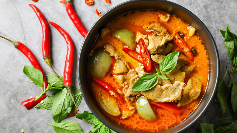 Red curry in a bowl with chile peppers