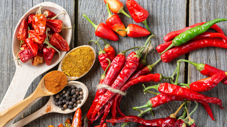 Spoons of peppers and whole peppers