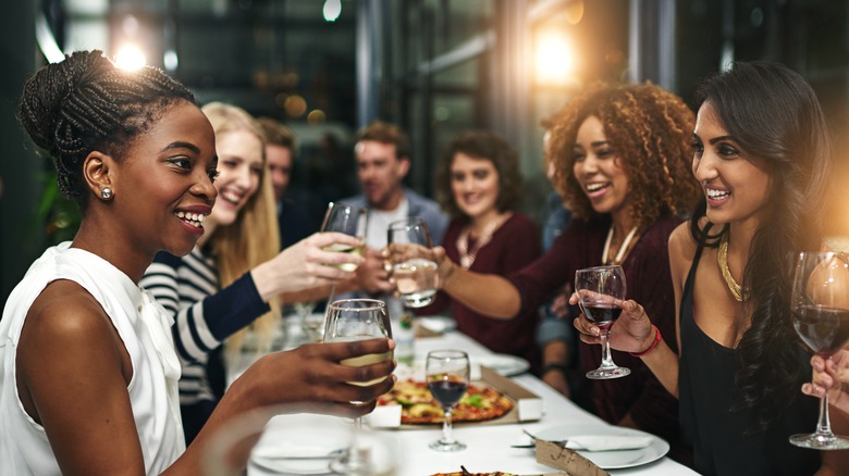 Group of friends raise glasses in fine dining restaurant