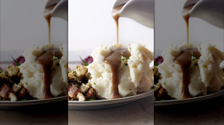 Gravy being poured onto mashed potatoes