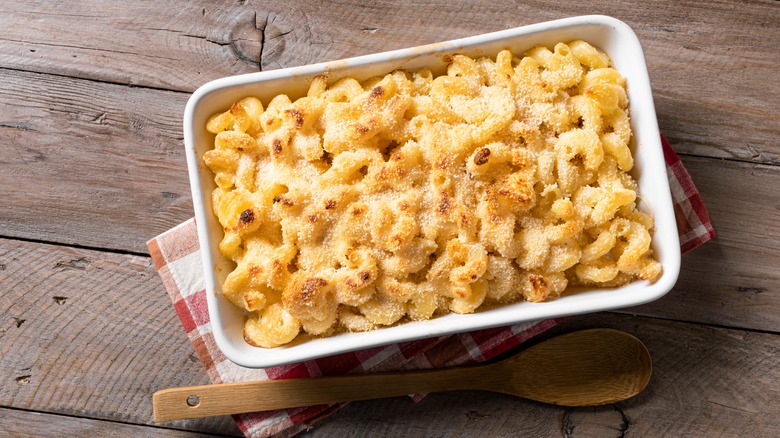 Mac and cheese casserole in a white dish on a wooden table