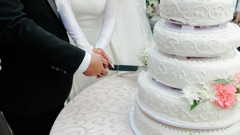 Couple cutting wedding cake