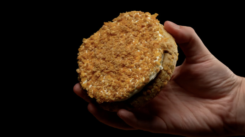 Hand holding a cinnamon cookie with a crumbly topping