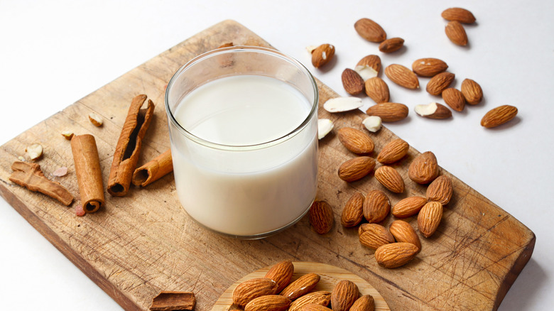 Glass of almond milk on a wooden serving board