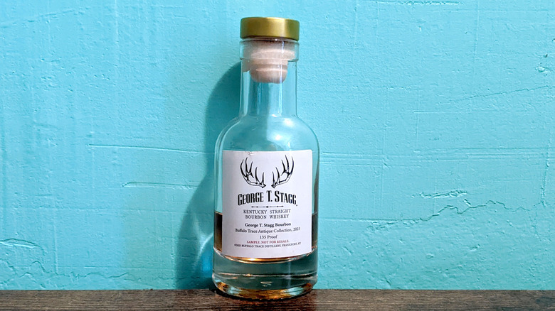 George T. Stagg bottle on wooden table in front of blue wall