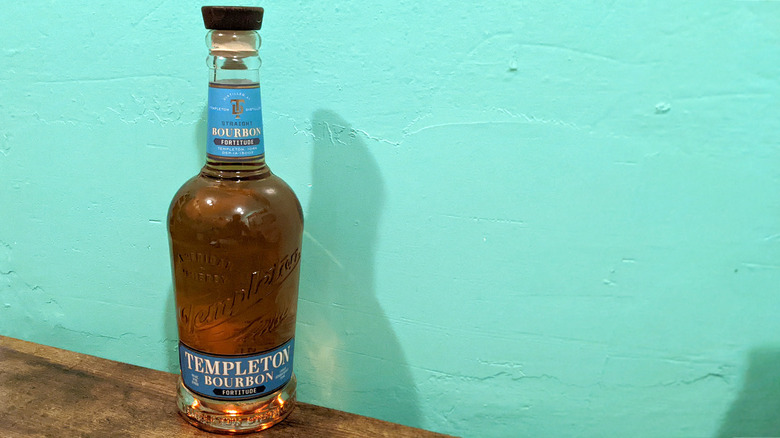 Templeton Fortitude bottle on wooden table in front of blue wall