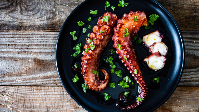 grilled octopus on black plate 